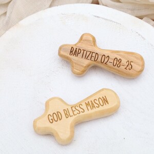 May include: Two wooden crosses with engraved messages. One cross reads "BAPTIZED 02-08-25" and the other cross reads "GOD BLESS MASON".