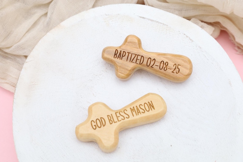 May include: Two wooden crosses with engraved messages. One cross reads "BAPTIZED 02-08-25" and the other cross reads "GOD BLESS MASON".