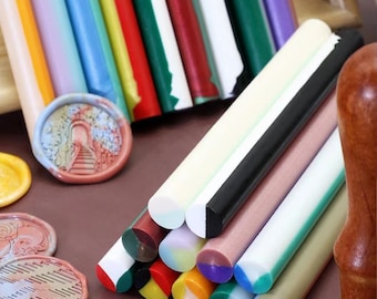 May include: Assortment of colorful wax sticks for sealing envelopes, letters, and invitations. The sticks are arranged in a stack with the ends of the sticks visible. The sticks are in various colors, including red, green, blue, yellow, and white.
