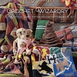 Puede incluir: La imagen muestra un libro de ganchillo titulado "CROCHET WIZARDRY" de las películas de Harry Potter. La escena incluye varios elementos de ganchillo: una muñeca Dobby, un Sombrero Seleccionador, una bufanda de Gryffindor y una manta con el escudo de Hogwarts. Un fénix está en una estantería.
