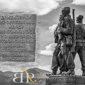 May include: A black and white photograph of a statue of three soldiers standing in a row. The statue is in front of a mountain range and a cloudy sky. A plaque on the left side of the image reads "In memory of the officers and men of the commandos who died in the Second World War 1939-1945 This country was their training ground."