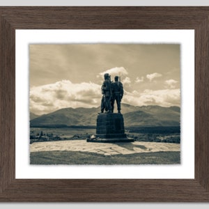 May include: A sepia toned photograph of a war memorial statue of two soldiers standing on a stone platform. The statue is set against a backdrop of mountains and a cloudy sky.