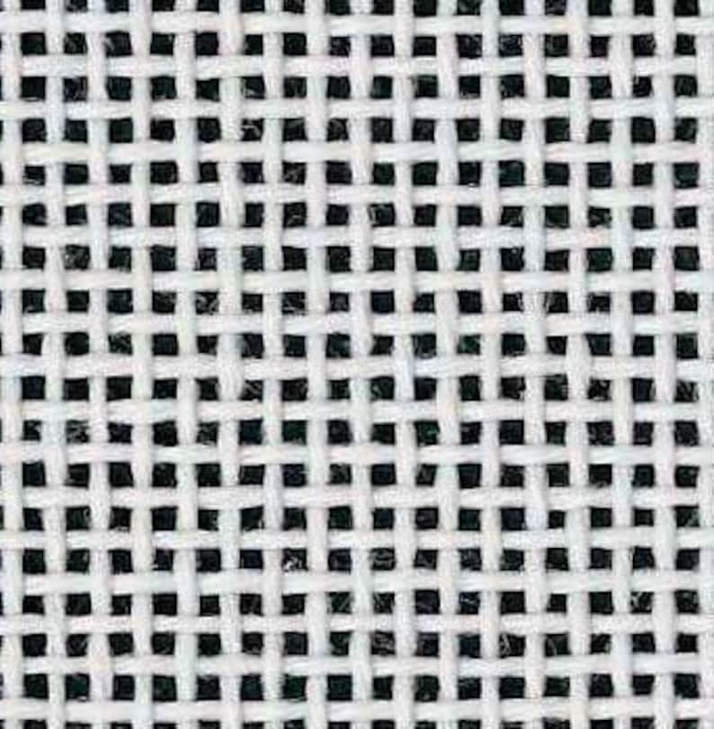 May include: Close-up of a white and black woven fabric. The fabric has a grid-like pattern, with white threads interlacing to create a series of small, evenly spaced squares. The black threads are visible in the background.