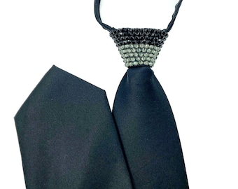 May include: A black satin tie with a black and clear rhinestone embellishment at the top.