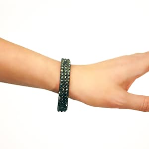 May include: A silver bracelet with three rows of sparkling rhinestones.