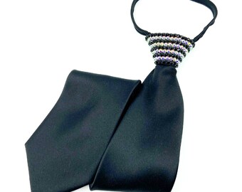 May include: A black satin tie with a black and iridescent crystal embellishment at the top.