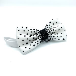 May include: White bow tie with black polka dots and a band of black rhinestones.
