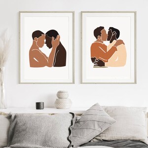 Puede incluir: Dos impresiones minimalistas de arte de l&iacute;nea de una pareja abraz&aacute;ndose. Las impresiones est&aacute;n enmarcadas en un marco de madera claro y est&aacute;n colgadas en una pared blanca.