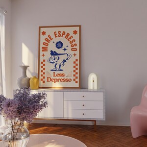 May include: A framed poster with the text "More Espresso Less Depresso" and a cartoon coffee cup character. The poster is in a brown frame with a cream background and orange and blue accents. The poster is displayed on a white cabinet.