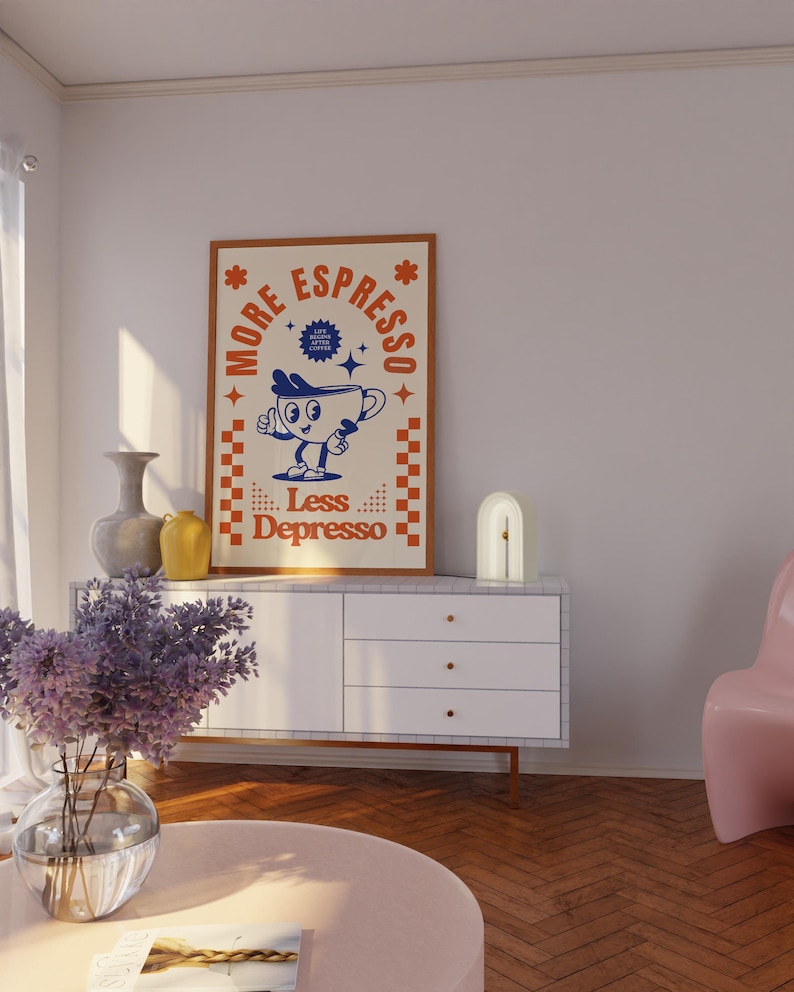 May include: A framed poster with the text "More Espresso Less Depresso" and a cartoon coffee cup character. The poster is in a brown frame with a cream background and orange and blue accents. The poster is displayed on a white cabinet.