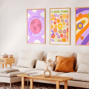 Puede incluir: Tres impresiones enmarcadas con una est&eacute;tica retro de los a&ntilde;os 70. La primera impresi&oacute;n presenta un globo terr&aacute;queo rosa con el texto "El mundo es un lugar mejor contigo en &eacute;l". La segunda impresi&oacute;n presenta un patr&oacute;n floral colorido con el texto "Flower Power". La tercera impresi&oacute;n presenta un arco&iacute;ris con caras sonrientes y corazones.