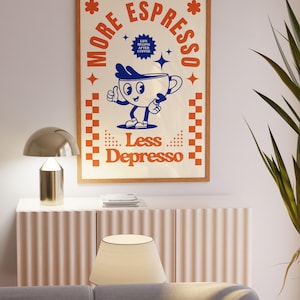 May include: A framed poster with a retro design. The poster features a cartoon coffee cup with the text "More Espresso, Less Depresso." The color scheme includes cream, orange, and blue. The poster is in a wooden frame.
