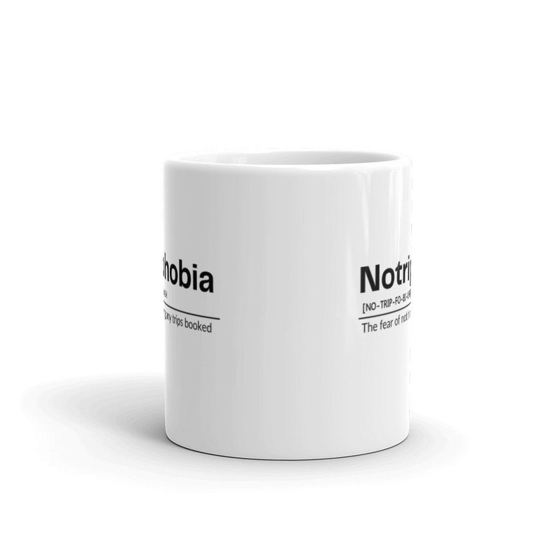 May include: White ceramic mug with black text that reads "NoTriphobia [NO-TRIP-FO-BIA] The fear of not taking trips".