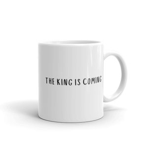 May include: White ceramic coffee mug with black text that reads "THE KING IS COMING".