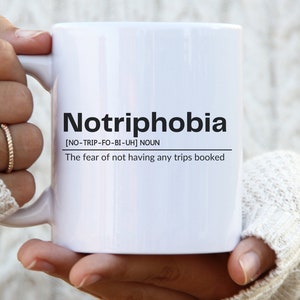 May include: White ceramic mug with black text that reads "Notriphobia [NO-TRIP-FO-BI-UH] NOUN The fear of not having any trips booked"