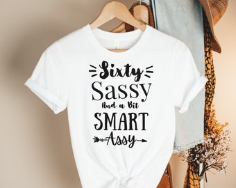 Peut inclure: T-shirt blanc avec un texte noir qui dit "Sixty Sassy And a Bit SMART Assy" avec une flèche pointant vers la droite.
