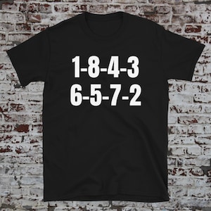 May include: Black t-shirt with white text that reads "1-8-4-3 6-5-7-2".