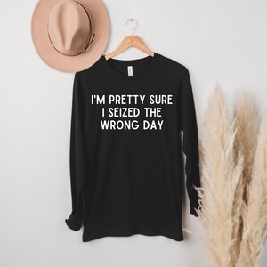 May include: Black long-sleeve shirt with white text that reads "I'm pretty sure I seized the wrong day."
