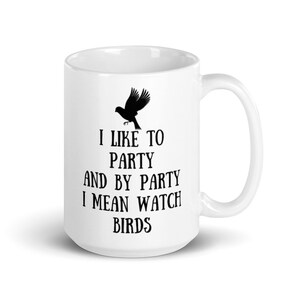 May include: White ceramic mug with a black silhouette of a bird and the text "I like to party and by party I mean watch birds".