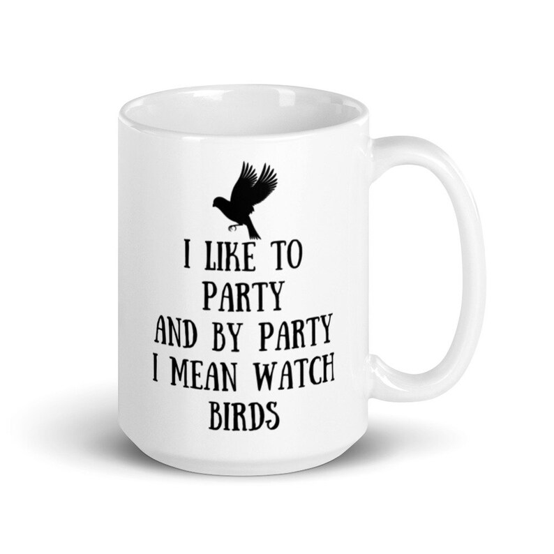 May include: White ceramic mug with a black silhouette of a bird and the text "I like to party and by party I mean watch birds".