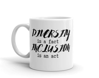 May include: White ceramic coffee mug with black text that reads "Diversity is a fact, Inclusion is an act."