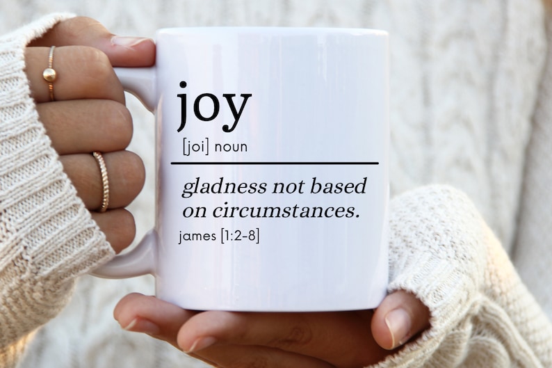 May include: White ceramic mug with black text that reads "joy [joi] noun gladness not based on circumstances. james [1:2-8]"