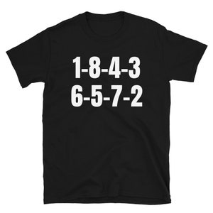 Peut inclure: T-shirt noir avec du texte blanc qui dit "1-8-4-3 6-5-7-2".