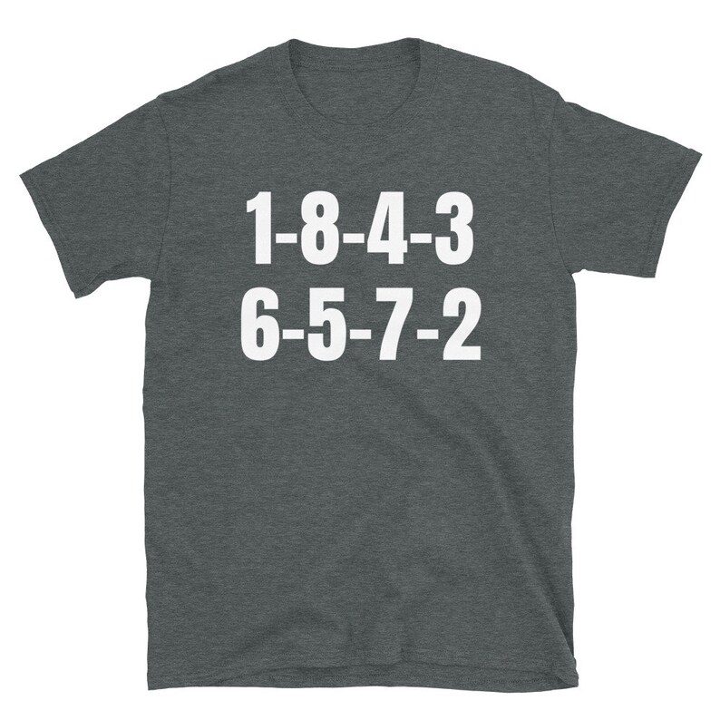 Peut inclure: Un t-shirt gris fonc&eacute; avec du texte blanc qui dit "1-8-4-3 6-5-7-2".