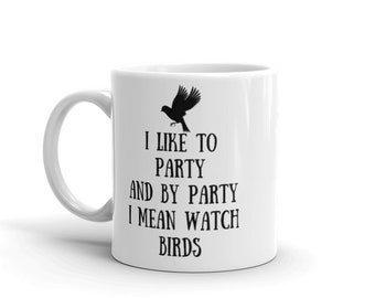 May include: White ceramic coffee mug with a black silhouette of a bird and the text "I like to party and by party I mean watch birds".
