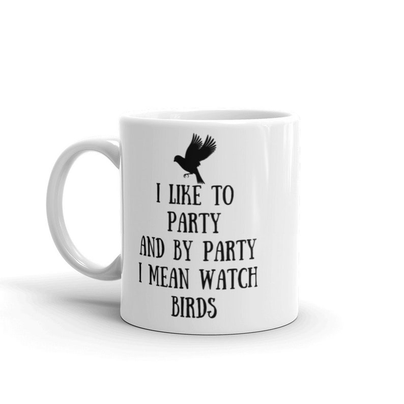 May include: White ceramic coffee mug with a black silhouette of a bird and the text "I like to party and by party I mean watch birds".