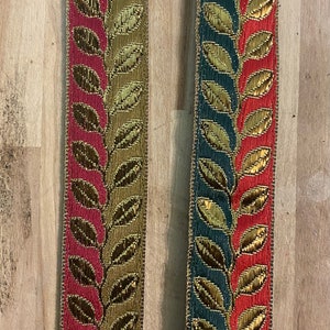 May include: Two pieces of gold and red trim with a leaf pattern. The trim on the left is gold and red, while the trim on the right is green and red.