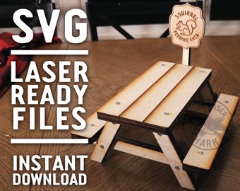Puede incluir: Una mesa de picnic de madera en miniatura con un letrero que dice "Squirrel Feeding Area" y una silueta de ardilla. La mesa está sobre una superficie de madera. El texto "SVG Laser Ready Files Instant Download @LaserSharkSVG" está en el lado izquierdo de la imagen.