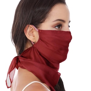 May include: A deep red, semi-sheer fabric face covering designed with a triangular scarf-like shape that extends down the neck. The mask features thin, light-coloured elastic ear loops to secure the lightweight material over the nose and mouth.