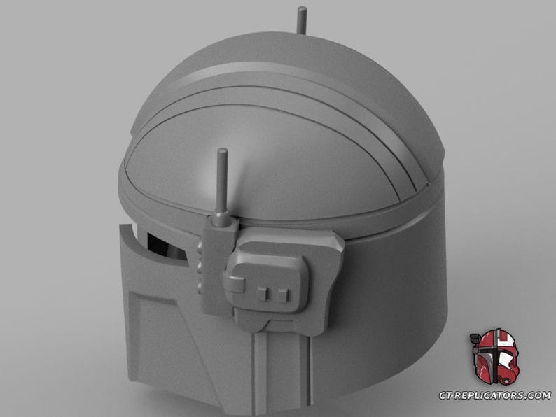 Puede incluir: Un casco gris mandaloriano con una parte superior redondeada y protuberancias en forma de antena. El casco presenta crestas horizontales y un componente lateral rectangular. La imagen incluye un logotipo en la esquina inferior derecha.