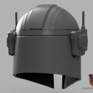 Puede incluir: Un casco gris con una parte superior redondeada, accesorios laterales y dos antenas verticales. El casco tiene una abertura para la visera y es probablemente un accesorio o una pieza de vestuario. El dise&ntilde;o recuerda una est&eacute;tica de ciencia ficci&oacute;n o militar.