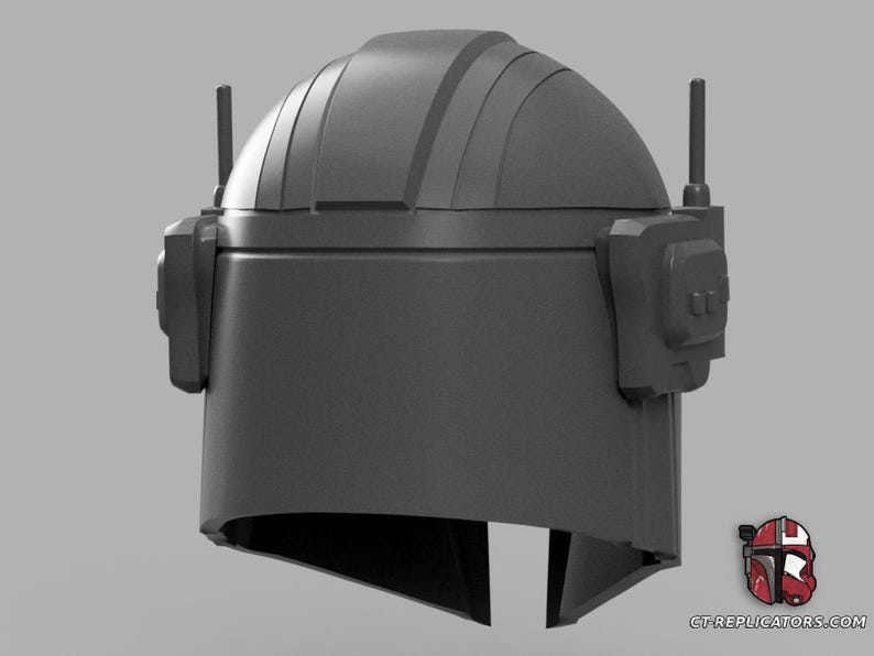 Puede incluir: Un casco gris con una parte superior redondeada, accesorios laterales y dos antenas verticales. El casco tiene una abertura para la visera y es probablemente un accesorio o una pieza de vestuario. El dise&ntilde;o recuerda una est&eacute;tica de ciencia ficci&oacute;n o militar.
