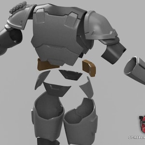 Puede incluir: Un conjunto de armadura gris y marr&oacute;n desmontado, probablemente para cosplay o exhibici&oacute;n. Las piezas incluyen componentes de pecho, hombros, brazos y piernas, lo que sugiere un traje completo. El dise&ntilde;o parece futurista y detallado, con un logotipo en la esquina inferior derecha.