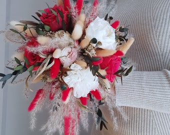 May include: A bouquet of dried flowers with red roses, white peonies, and fluffy white pampas grass.