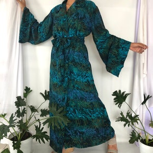 May include: A long, teal blue and green floral print robe with a tie belt and wide bell sleeves.