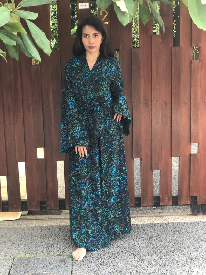 May include: A long black and blue robe with a leaf pattern. The robe has a tie belt and long sleeves.