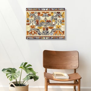 Peut inclure: Tableau carr&eacute; avec un motif d'art populaire, sur fond beige et bord&eacute;. L'&oelig;uvre pr&eacute;sente des figures stylis&eacute;es, des animaux et des motifs floraux dans des tons orange, bleu et jaune. La toile est accroch&eacute;e &agrave; un mur blanc, avec une chaise en bois et une plante au premier plan.