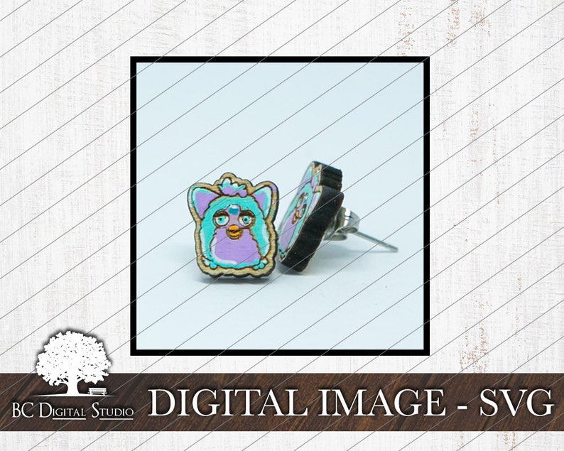 May include: A pair of earrings featuring a purple and blue fuzzy creature with a pink nose and yellow eyes. The earrings are made of wood and have silver posts.