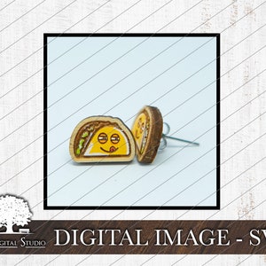 May include: A pair of wooden taco earrings with a smiling face and a tongue sticking out. The earrings are brown with yellow, green, and red details.