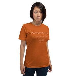 May include: A burnt orange t-shirt with white text that reads "MUULTIPASS -LEELOO MINAS LEKATANIS LAMINA TCHAI ERBAT DE SEBAT"