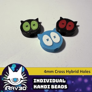 Op de afbeelding: Drie 4 mm kandi kralen met kruis-hybride gaten. Eén kraal is zwart met groene ogen, één is zwart met rode ogen en één is blauw met witte ogen.