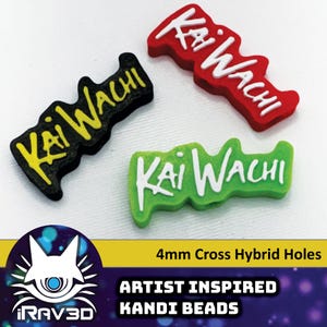 May include: Three plastic kandi beads with the text "Kai Wachi" in white lettering on a black, red, and green background. The beads have 4mm cross hybrid holes.