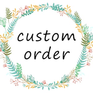 May include: A floral wreath in shades of green, blue, orange, and red encircles the words "custom order" in black script. The design features a variety of leaves and small flowers, creating a decorative border.