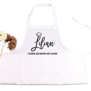 May include: White apron with a black chef hat and the name "Lilian" written in cursive. The text "I cook as good as I look" is printed below the name.