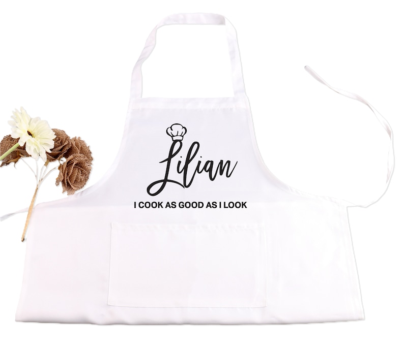 May include: White apron with a black chef hat and the name "Lilian" written in cursive. The text "I cook as good as I look" is printed below the name.