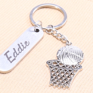 Puede incluir: Llavero de baloncesto plateado con una etiqueta de nombre personalizada que dice "Eddie".